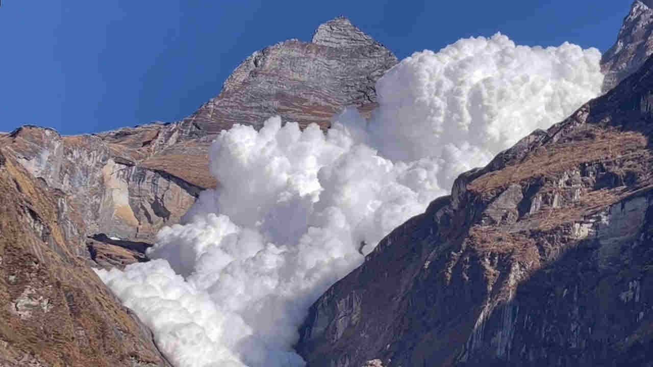 La valanga che scivola dalla montagna sopra il lago